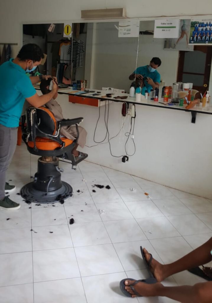 barbearia manu at work in his barbershop in vila do maio